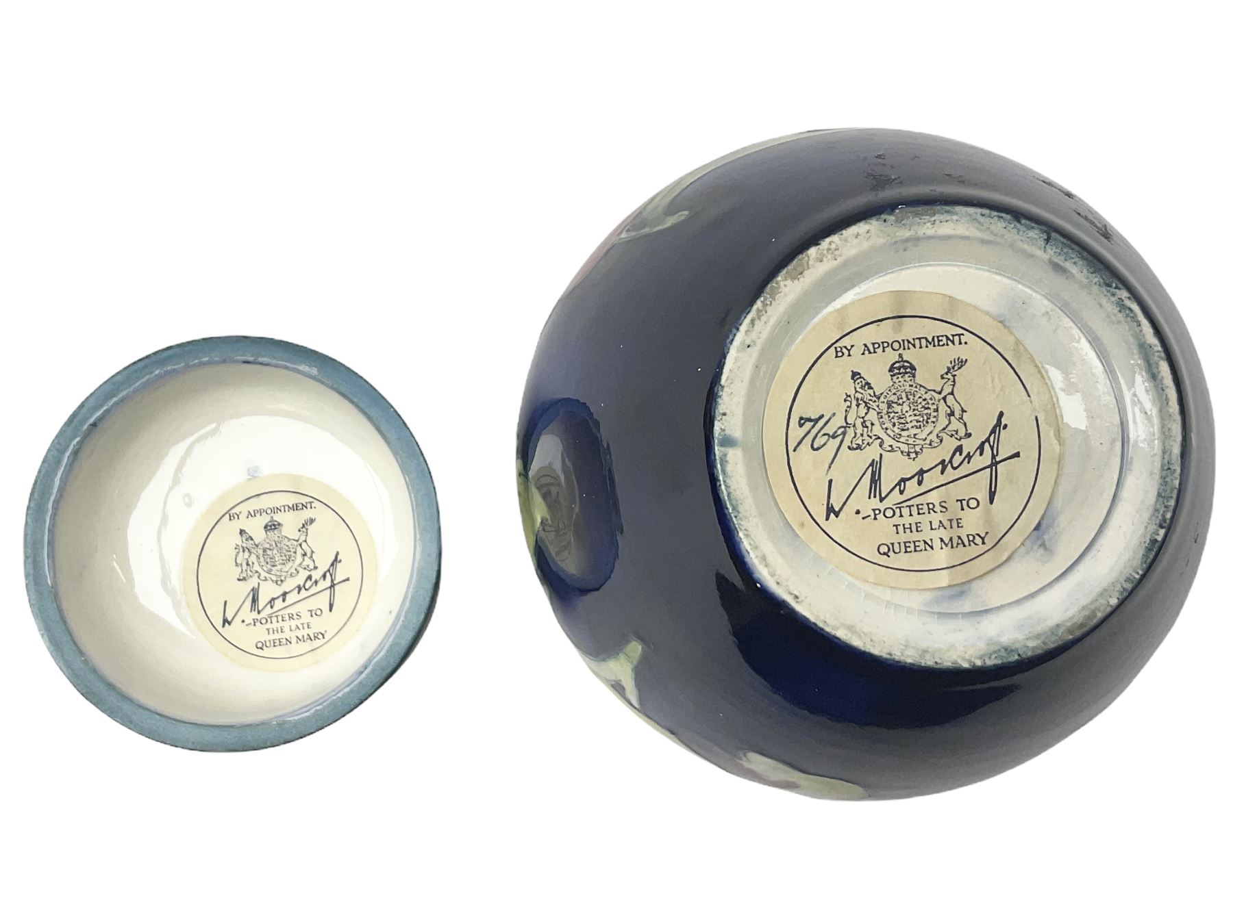 Moorcroft ginger jar, decorated in the Hibiscus pattern upon a blue ground, with paper label beneath detailed 'Potters to the late Queen Mary', H11cm.