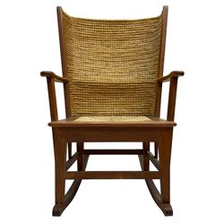 Reynold Eunson (1932–1978) for David Munro Kirkness, Kirkwall, Orkney - oak framed Orkney rocking chair, woven straw curved back, drop-in rush seat, the arm terminals with carved end scroll, on square tapering supports joined by plain stretchers, the front rail inscribed with makers marks