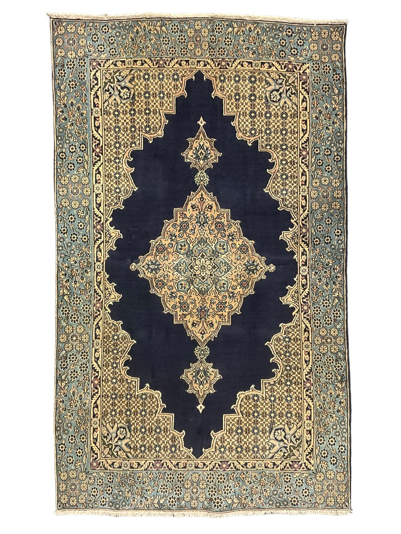 Central Persian Qum indigo ground rug with silk inlay, the plain field decorated with floral design medallion and lattice spandrels, the wide border decorated with trailing flowers and foliage 