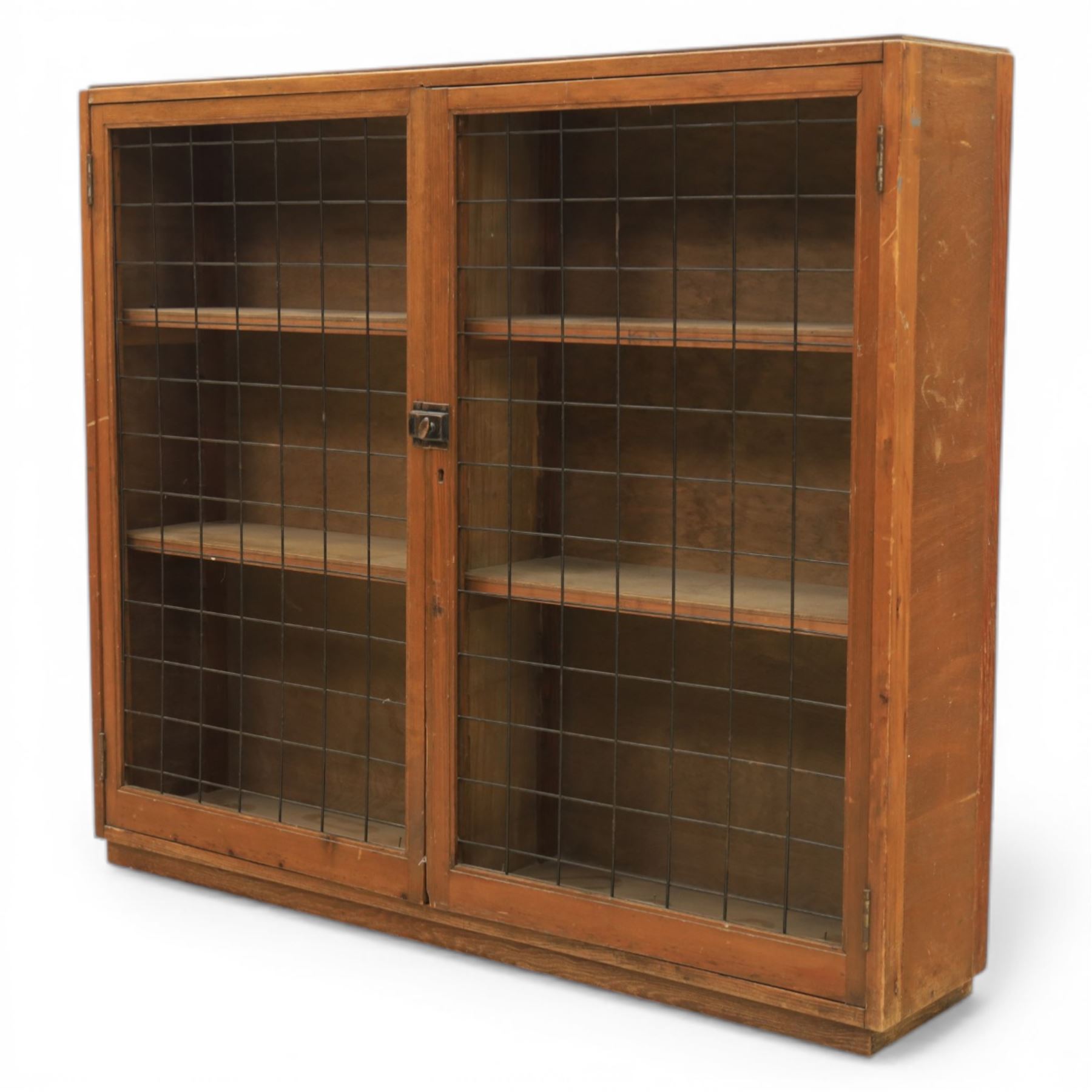 Rustic pine cupboard fitted with wire panelled doors, enclosing staggered adjustable shelving