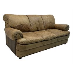 Contemporary three-seat sofa, upholstered in stitched brown leather with brass studwork decoration, rolled back and arms, raised on turned supports