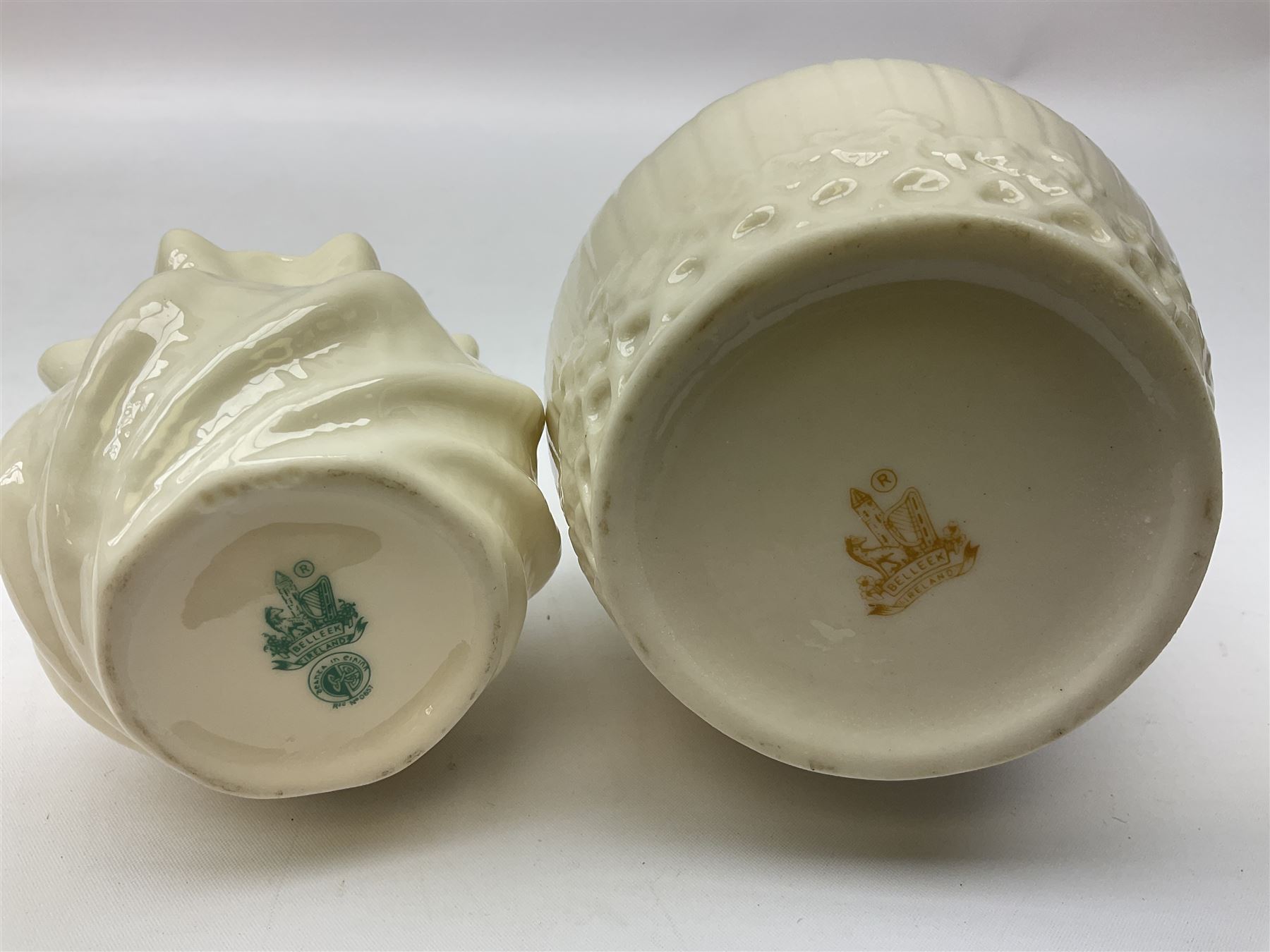 Quantity of Belleek ceramics to include mid-late 19th century jug moulded with green man mask and foliage, date code stamp for 1863-1890, together with later Belleek cornucopia shape vase, jug and other vases together with a Belleek style shell dish raised on branches, tallest H19cm