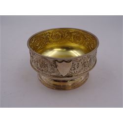 Victorian silver bowl, with embossed floral decoration and beaded rim, gilt interior and two applied shield cartouches, upon stepped circular foot, with a silver apostle spoon, with gilt bowl, both hallmarked George Unite, Birmingham 1883, bowl H5.5cm, within fitted tooled leather, silk lined case