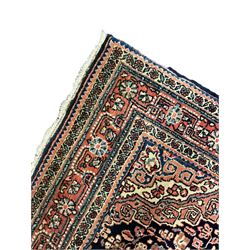 Persian indigo ground rug, the field decorated with intricate interlaced foliage branches and small flower heads, shaped floral design central medallion, the border decorated with scrolling branch and flower heads within guard bands 