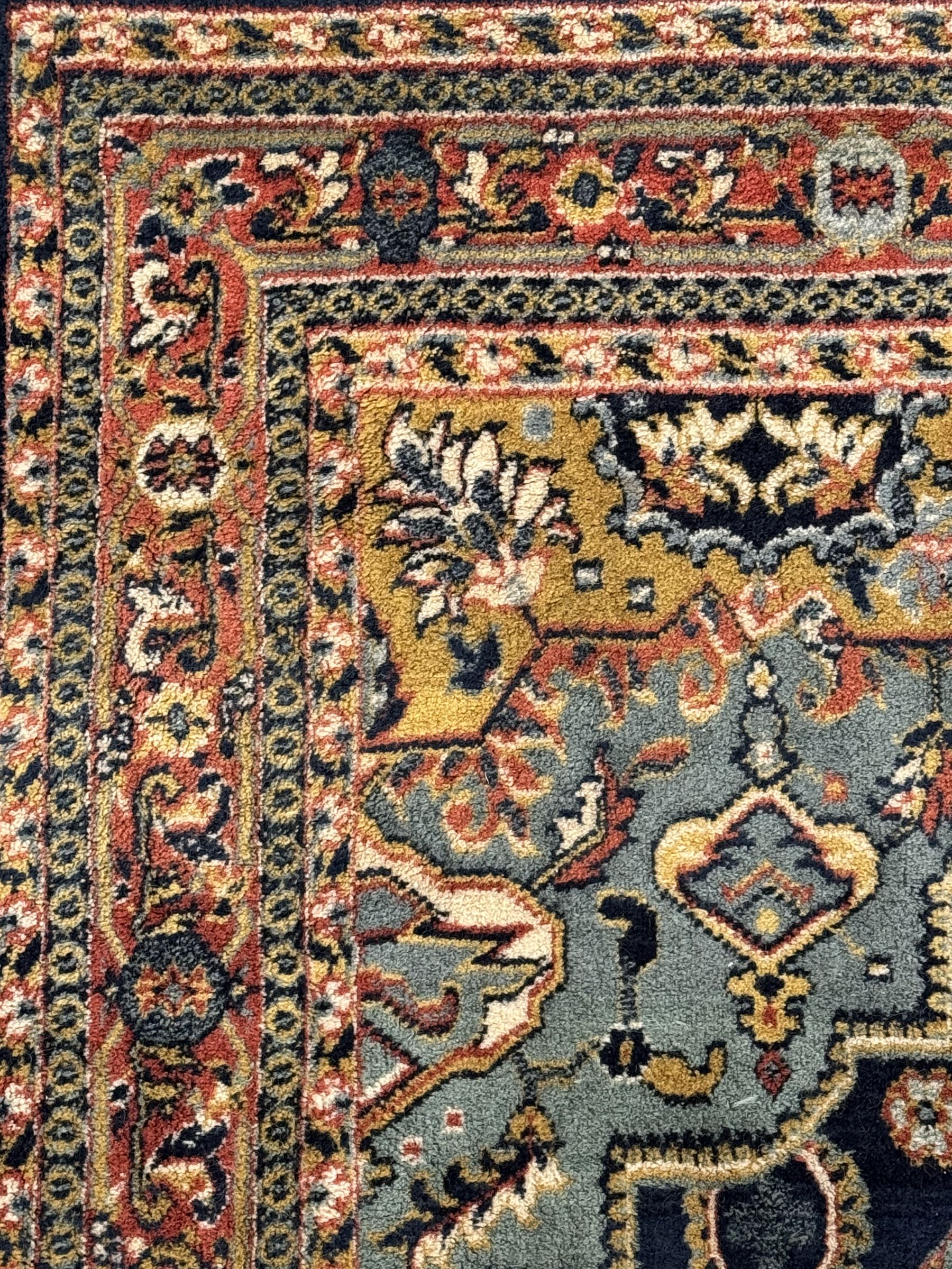 Belgian Sultan woollen ground rug, central navy field densely decorated with floral sprays and geometric patterns (192cm x 135cm); handwoven tribal terracotta ground rug (121cm x 71cm); Persian crimson ground runner, all over stylised floral and foliate motifs (266cm x 94cm)