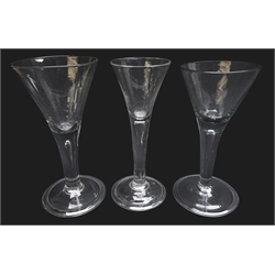  Three wine glasses each with trumpet bowl rising from a thick plain stem enclosing a single tear on folded slightly domed foot, H17cm max (3)  