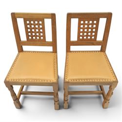 Mouseman - set of four oak lattice back chairs with tan seat with brass studded trim, with carved mouse signature, by the workshop of Robert Thompson of Kilburn
