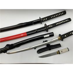 Reproduction Japanese sword daisho of katana and wakisashi with matching tanto; together with another reproduction katana; all with simulated fish skin grip and lacquered saya (4)