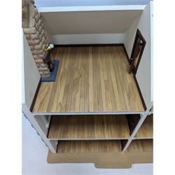 1:24 scale stone effect three-storey cottage dolls house, with green arched door and lattice effect windows, decorated to the interior with wooden floors, wired lighting and fire places, H45cm, W57cm, D26cm