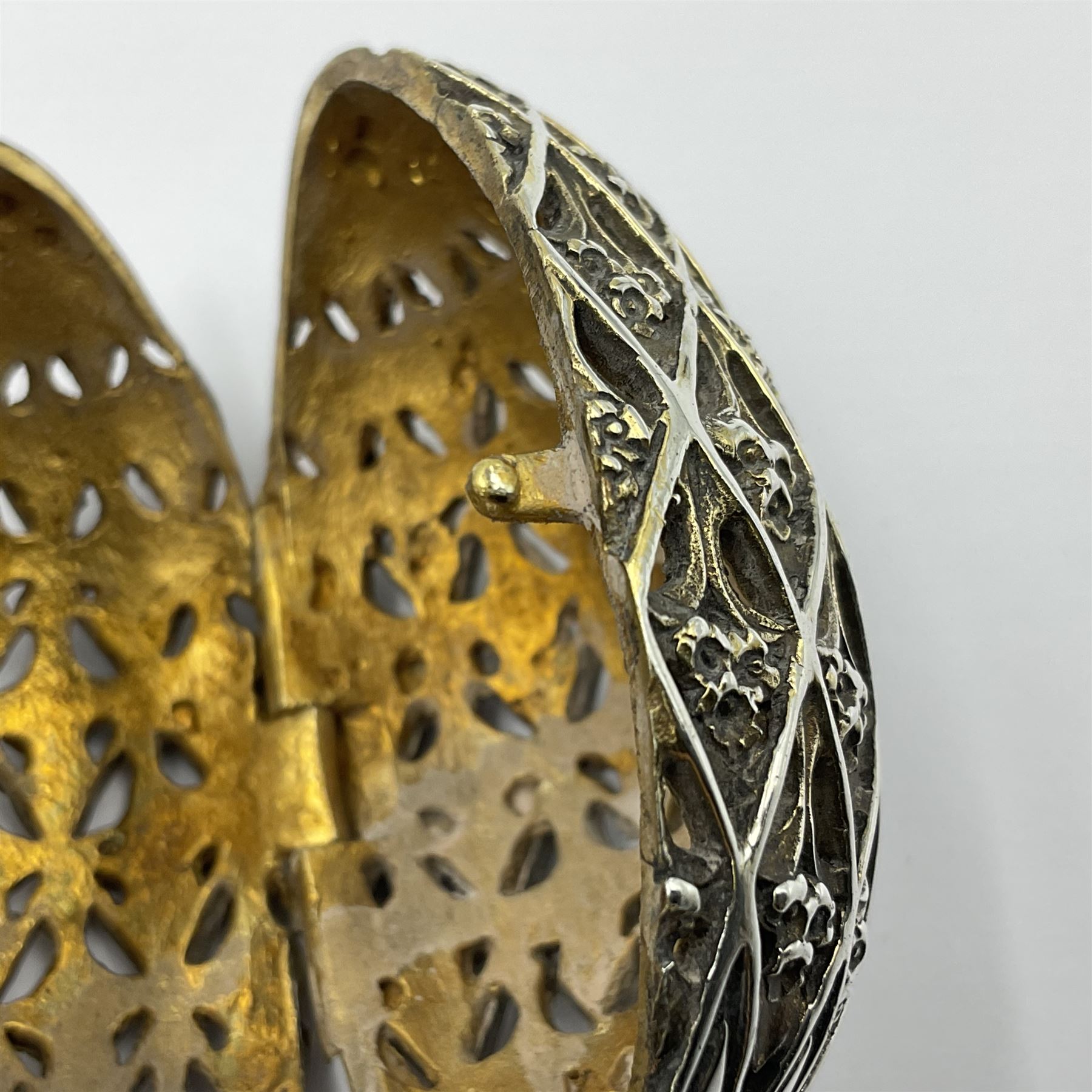 Modern silver limited edition Easter egg, no. 70/500, the openwork lattice body decorated with gilded panels of flower heads, opening to reveal a gilt interior, upon silver stand with three scrolling pad feet, each hallmarked St James House Company, London 1979, height including stand 8cm