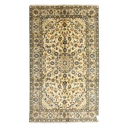 Central Persian Kashan hand-knotted rug, ivory ground, with a small central floral medalli...