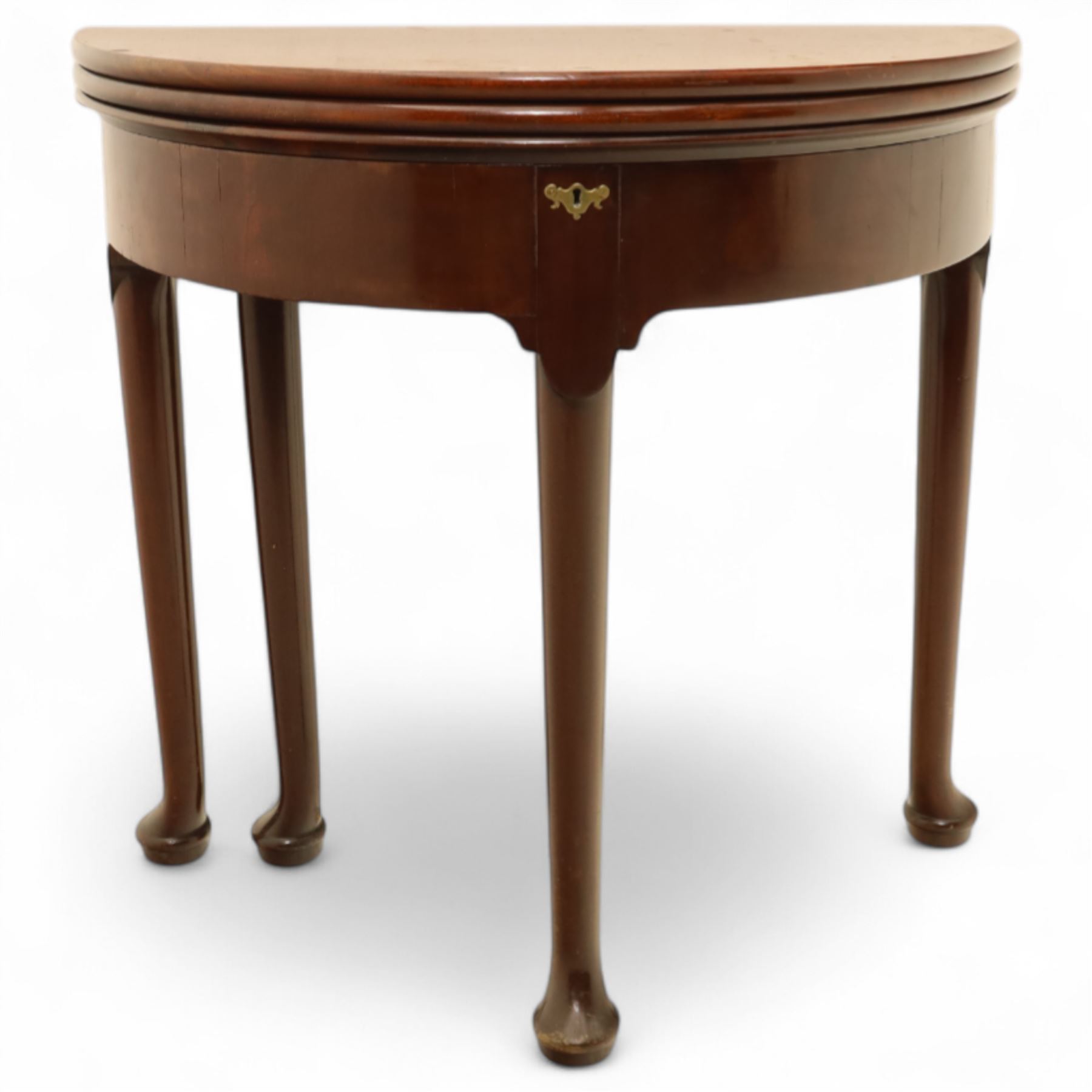 20th-century Georgian Revival style double fold-over card table, the first hinged circular top with polished mahogany surface above a second hinged circular top revealing a green baize playing surface with four counter-wells, underneath with a recessed compartment with and  chip and dice wells, the apron with fitted lock and key, raised on slender straight legs with pad feet 
