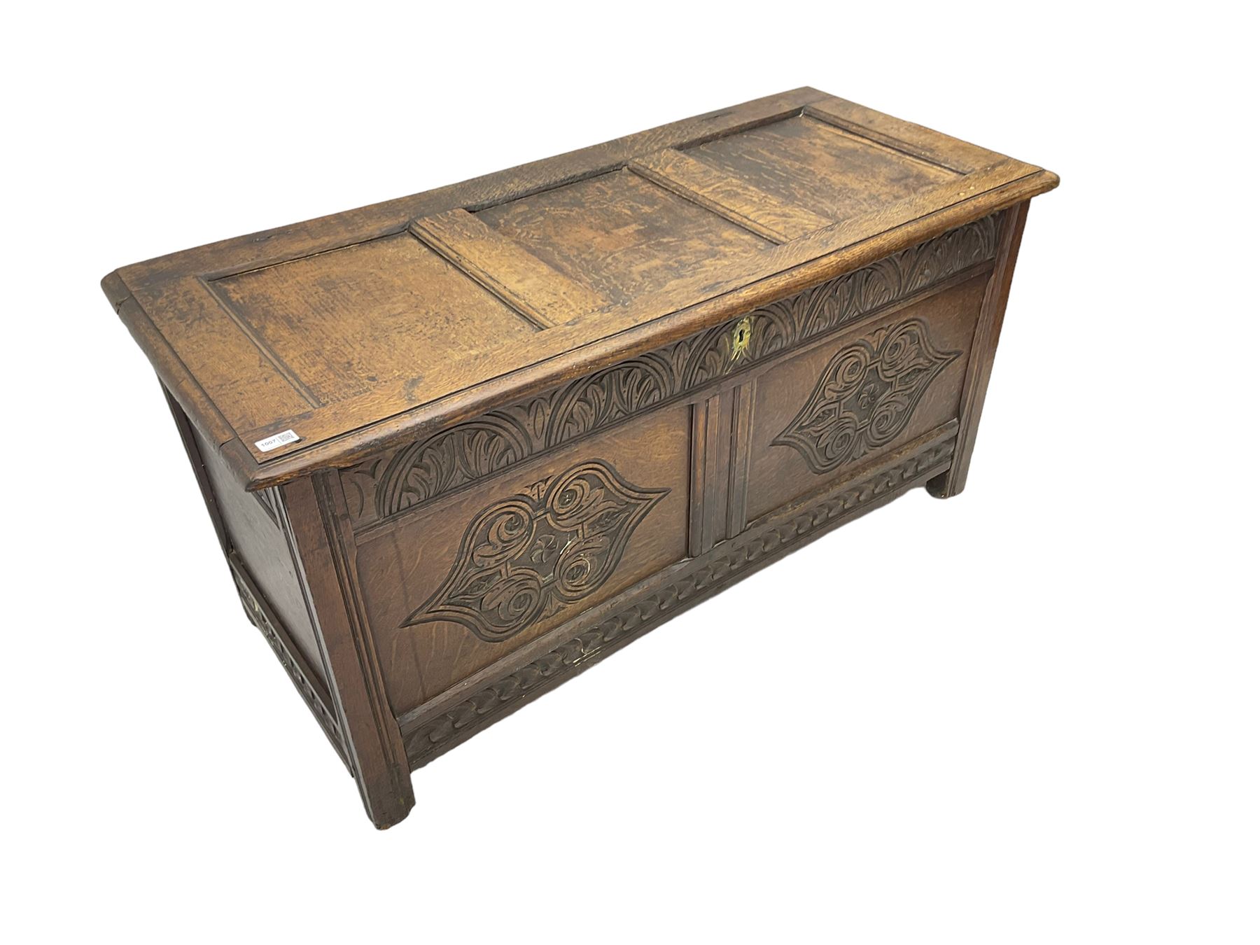 18th century oak blanket chest or coffer, rectangular hinged top with three panels and moulded edge, frieze carved with lunette and acanthus leaf decoration, two front panels carved with scrolling motif, raised on stile supports