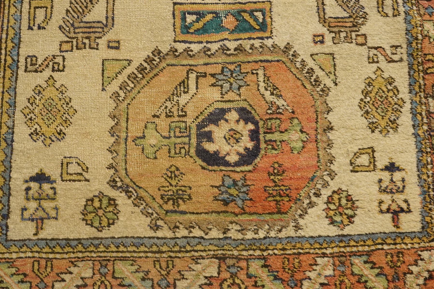Two Caucasian designed rugs comprising a flatweave and hand-knotted rug, Caucasian design flatweave, cream ground with three large blue geometric medallions surrounded by stylised birds and geometric motifs, enclosed by repeating geometric border, fringed ends, H176cm, W102cm; hand-knotted Caucasian rug, ivory ground with three polychrome octagonal medallions surrounded by stylised animals, flowerheads and geometric motifs, enclosed by salmon pink geometric border, fringed ends, H163cm, W106cm