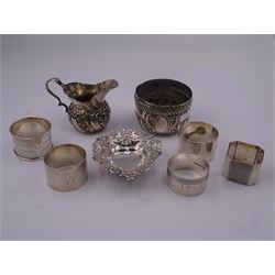 Group of five mid 20th century silver napkin rings, comprising a pair of plain circular form engraved with initial, hallmarked Viner's Ltd, Sheffield 1932, a circular example with engine turned bands, hallmarked R N Hollings & Co, Birmingham 1945, and two further 1930's examples, hallmarked Birmingham 1930 and 1934, various makers, together with a small early 20th century silver cream jug, of bellied form with foliate embossed decoration and scroll handle, hallmarked Walker & Hall, Sheffield 1910, including handle H6.5cm, etc.,  approximate total weight 8.98 ozt (279.3 grams)