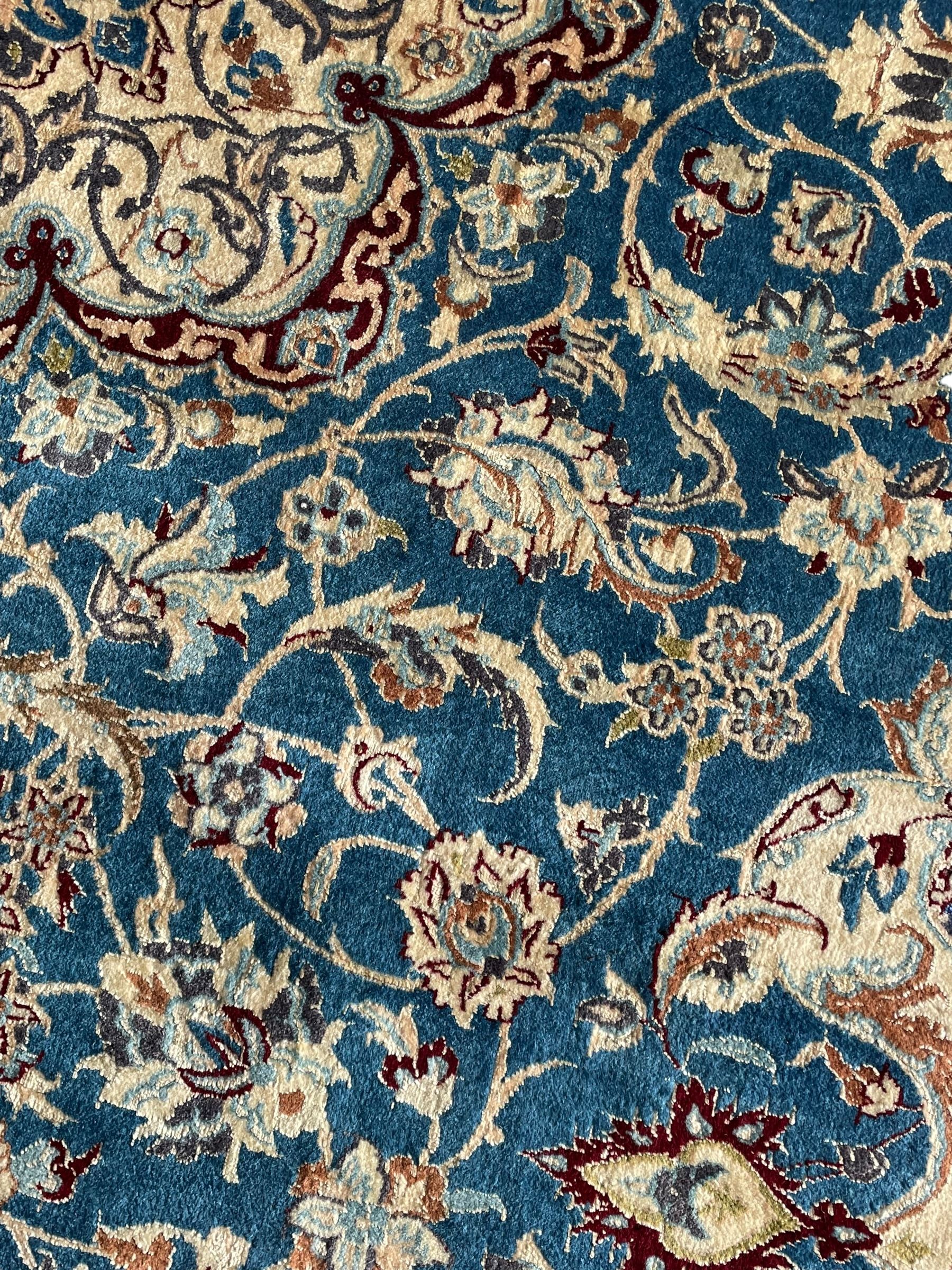 Persian Nain blue and ivory ground rug, wool with silk inlay, overall arabesque design, central medallion surrounded by interlacing and scrolled leafy branches and palmettes, the scrolling border decorated with stylised plant motifs, within guard stripes