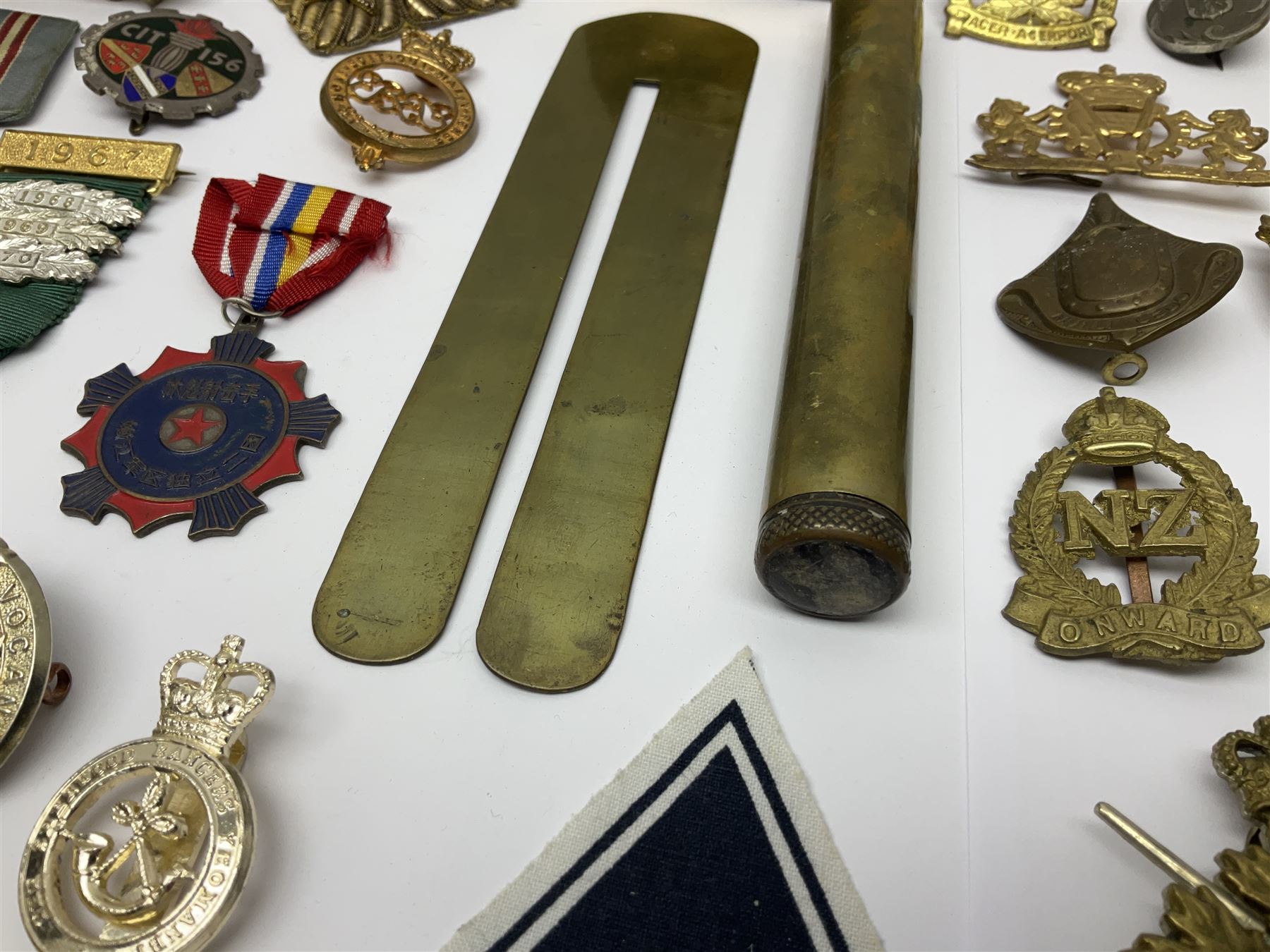Collection of approximately sixty worldwide medals, metal badges, belt buckles, cloth badges, trench art, brass button stick etc