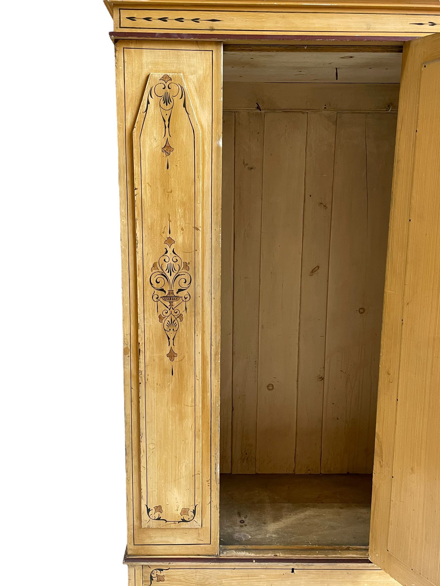 19th century painted pine wardrobe, the projecting cornice over mirror glazed door, with painted decoration depicting scrolling foliate and urns, drawer to base on skirt