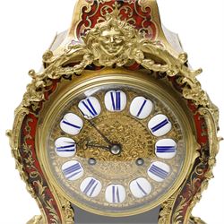 Rollin à Paris - 19th century French Louis XV style ormolu-mounted red tortoiseshell and brass Boulle-work mantel clock, surmounted by a seated musical putto above a waisted case applied with mask, rocaille, foliate and dolphin mounts, the gilt dial with white enamel Roman numeral cartouches, twin-train movement striking on a bell, signed and numbered 480, on four scrolling foliate feet
