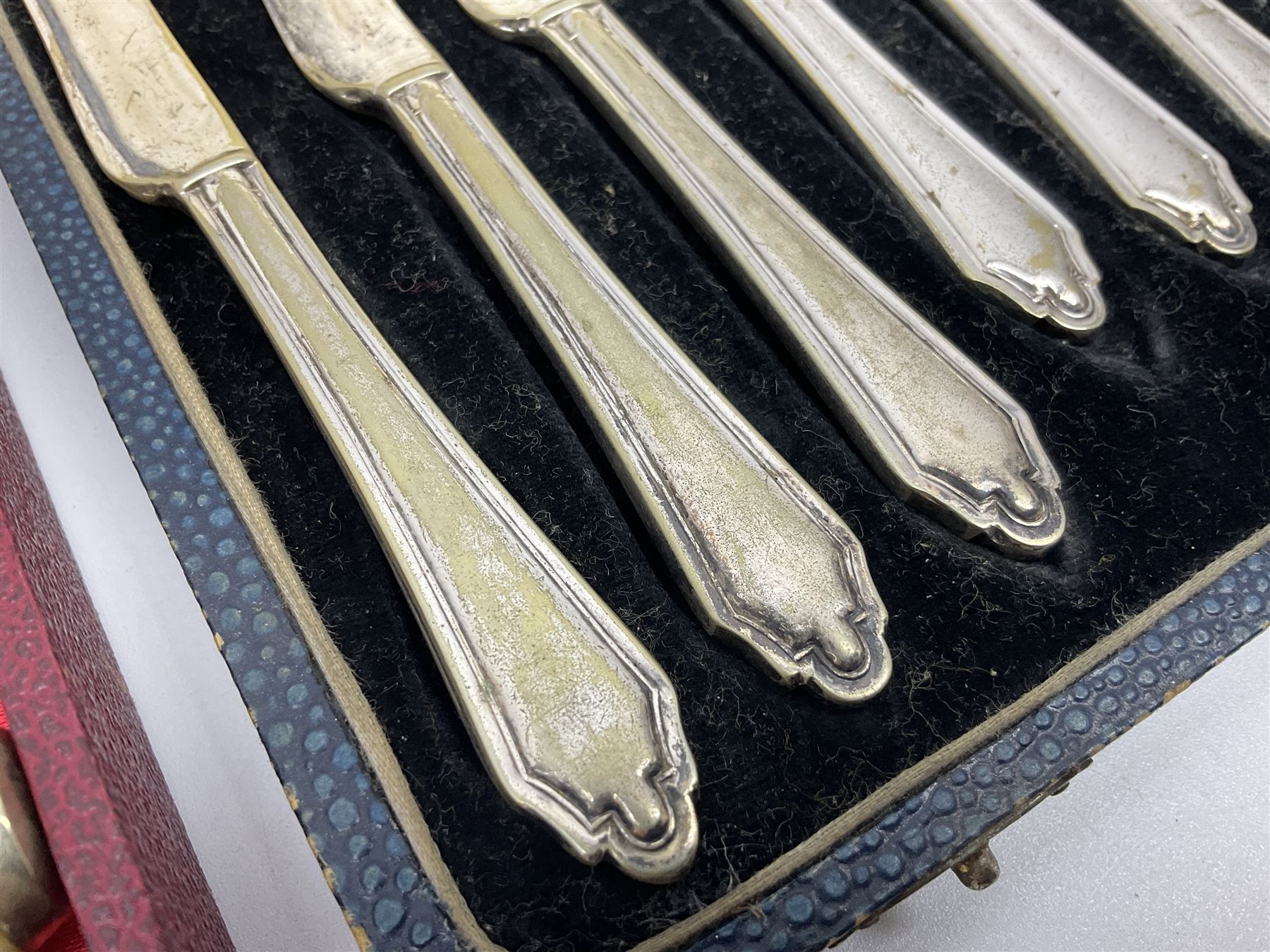 Set of six stag horn handled knives by Cooper Brothers and Sons, together with a set of silver plated dessert knives and forks for six place settings, both within fitted cases