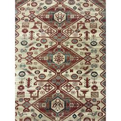 Persian design red ground rug, the field decorated with three interlinked lozenges and small stylised plant motifs, the multiple band border decorated with Boteh and floral motifs