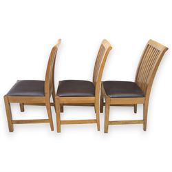 Contemporary oak extending dining table, moulded rectangular top with visible grain and inset extension leaf, pull out extending mechanism, standing on four square legs, accompanied by a set of high slat back chairs with upholstered brown faux leather seats and square tapering supports joined by stretchers