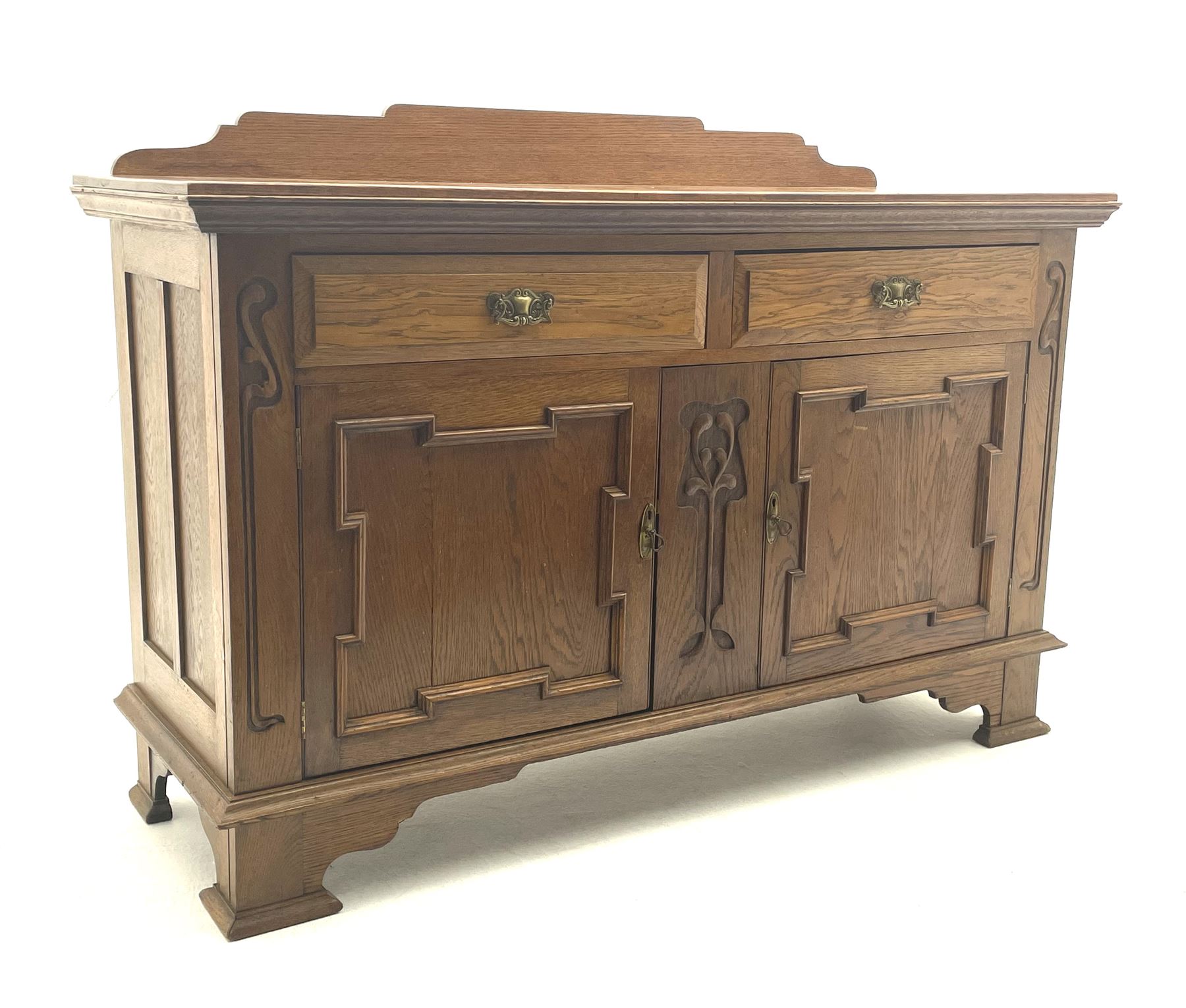 Edwardian oak sideboard, raised and shaped back, two short drawers above two cupboard doors enclosing fitted interior, shaped bracket supports