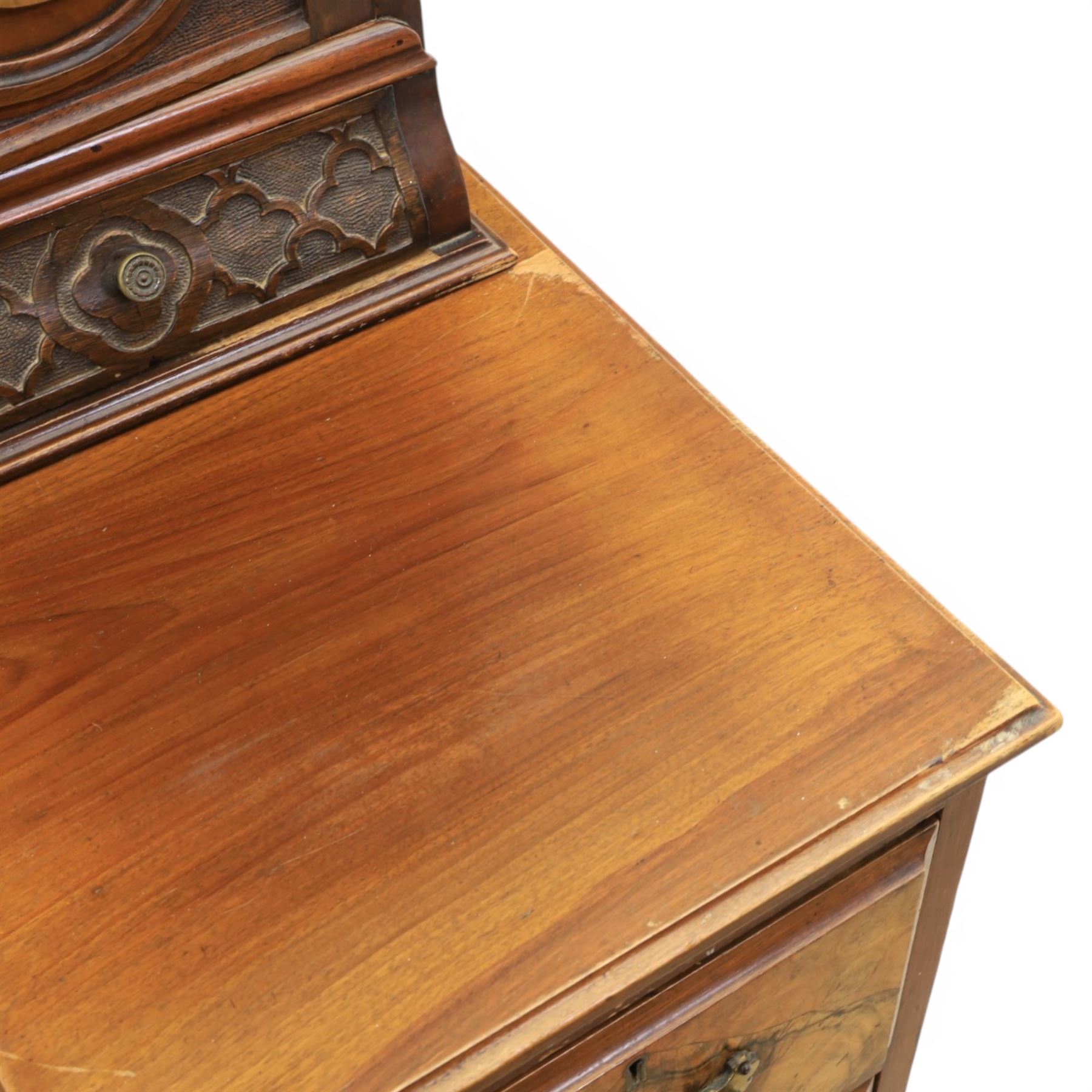 Edwardian figured walnut dressing chest, with central tilting mirror with pierced fret work, flanked by cabinet with figured walnut panelled door above a trinket drawer, with four short over a long long drawer, raised on a plinth base with castors 