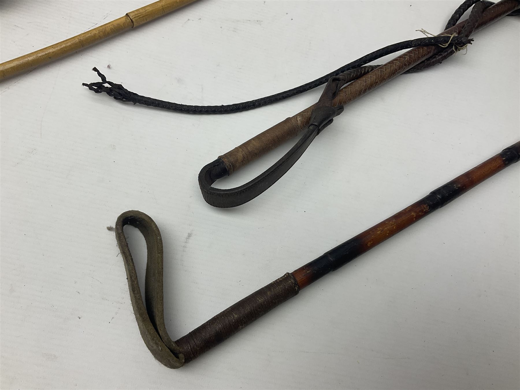 Collection of hunting crops and riding whips, including horn handle examples with silver cuffs