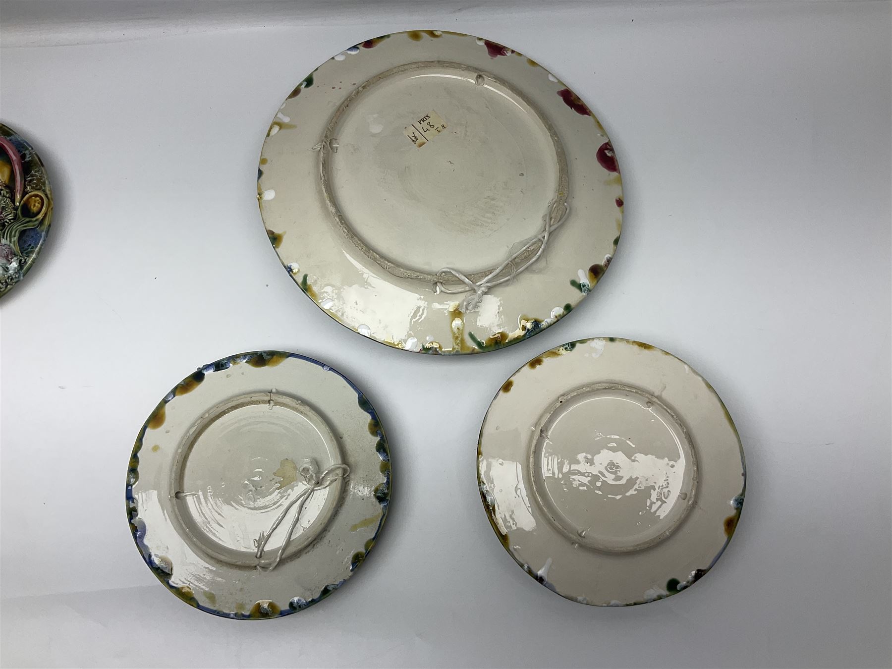 Five 20th Century Portuguese Palissy style Majolica wall plates, all depicting crustaceans to the centre modelled in relief surrounded by encrustations and shells, both with impress marks beneath, largest D29cm