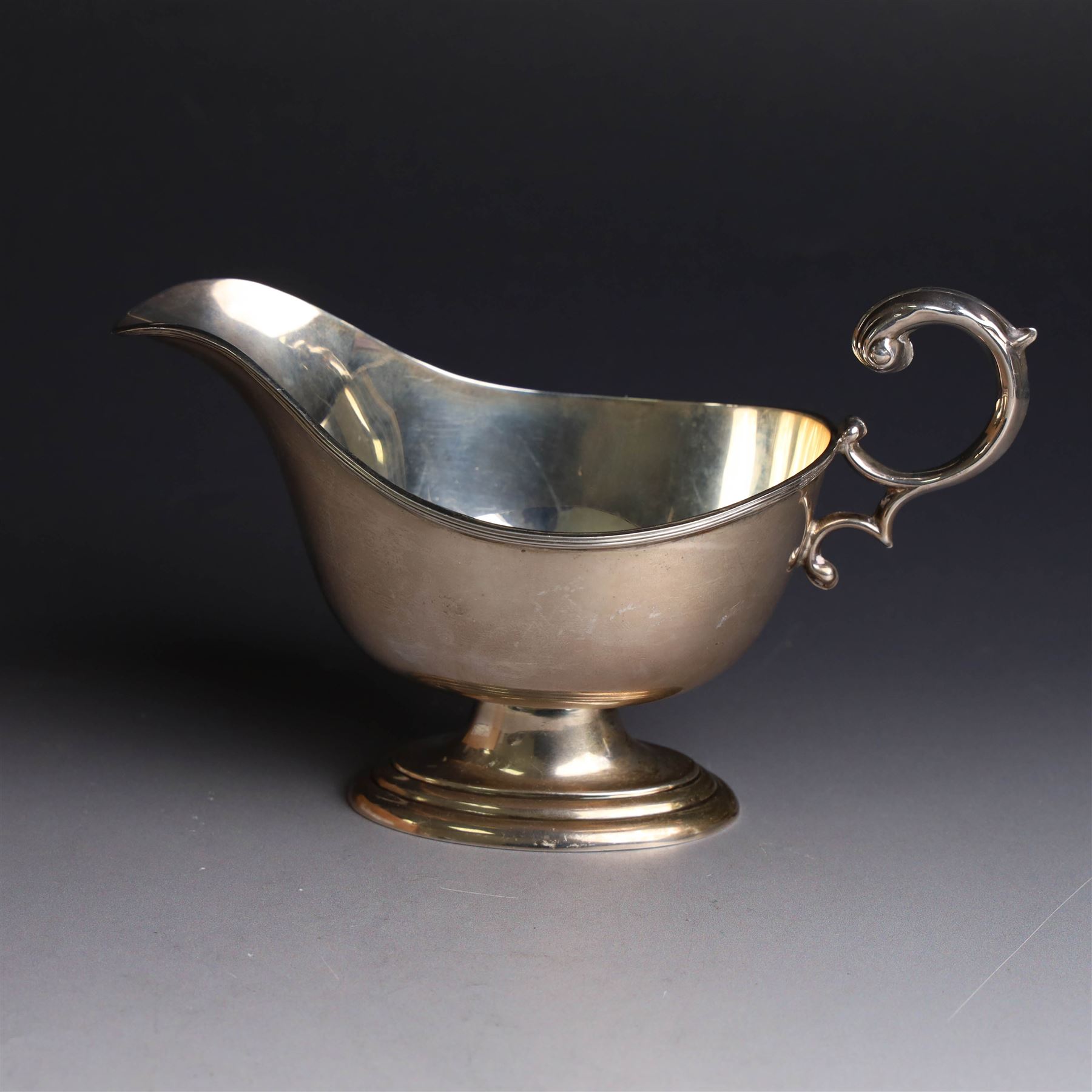 1930s silver sauce boat, of typical form with acanthus capped flying C scroll handle and upon stepped oval foot, hallmarked William Hutton & Sons Ltd, Sheffield 1938, height including handle H10cm