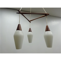  1970s Scandinavian teak three light centre light fitting, with white frosted tapered glass shades, in the style of designer & Uno Kristiansson, H89cm   
