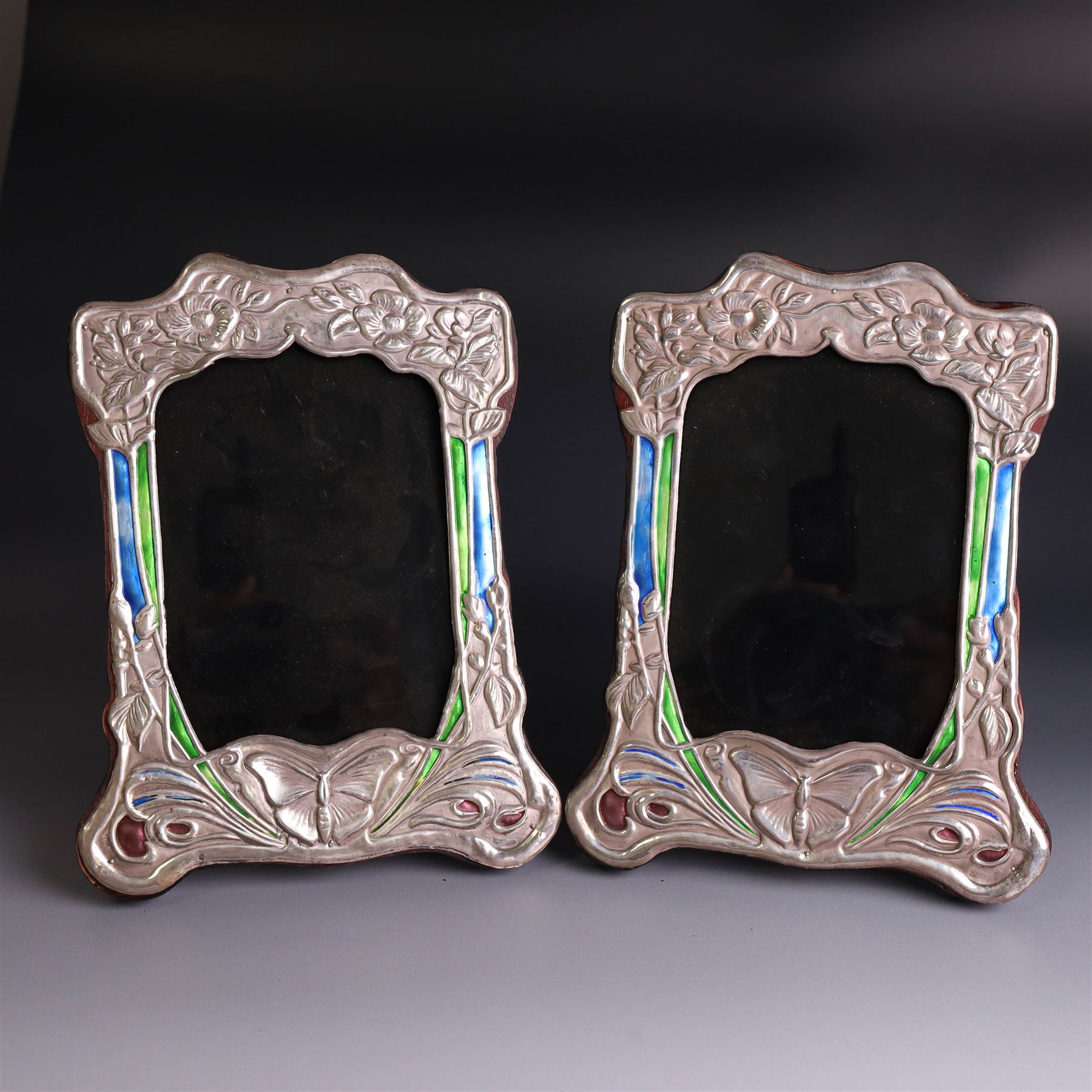 Pair of silver mounted Art Nouveau style photograph frames, with enamel butterfly and floral decoration, with wooden easel stands verso, stamped Sterling, H21cm