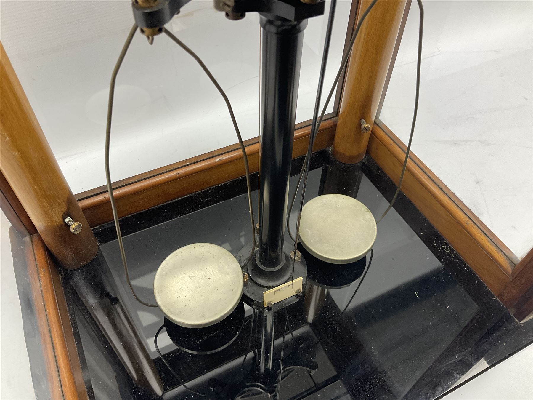 Set of laboratory balance scales by Reynolds & Branson of Leeds in fully glazed mahogany case with rise-and-fall front door, black vitrolite base with brass feet and hand cranked action L40cm H51.5cm D30cm; and bakelite cased set of brass weights