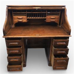 Globe Wernicke - Oak roll top desk, tambour roll top enclosing a fitted interior, raised on two pedestal bases with fitted drawers, raised on a plinth base 