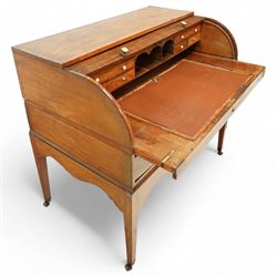 George III mahogany cylinder front writing desk, the hinged tambour enclosing pigeonholes and drawers with bone handles, sliding writing surface with leather inset, three frieze drawers below, on square tapering legs with brass caps and castors