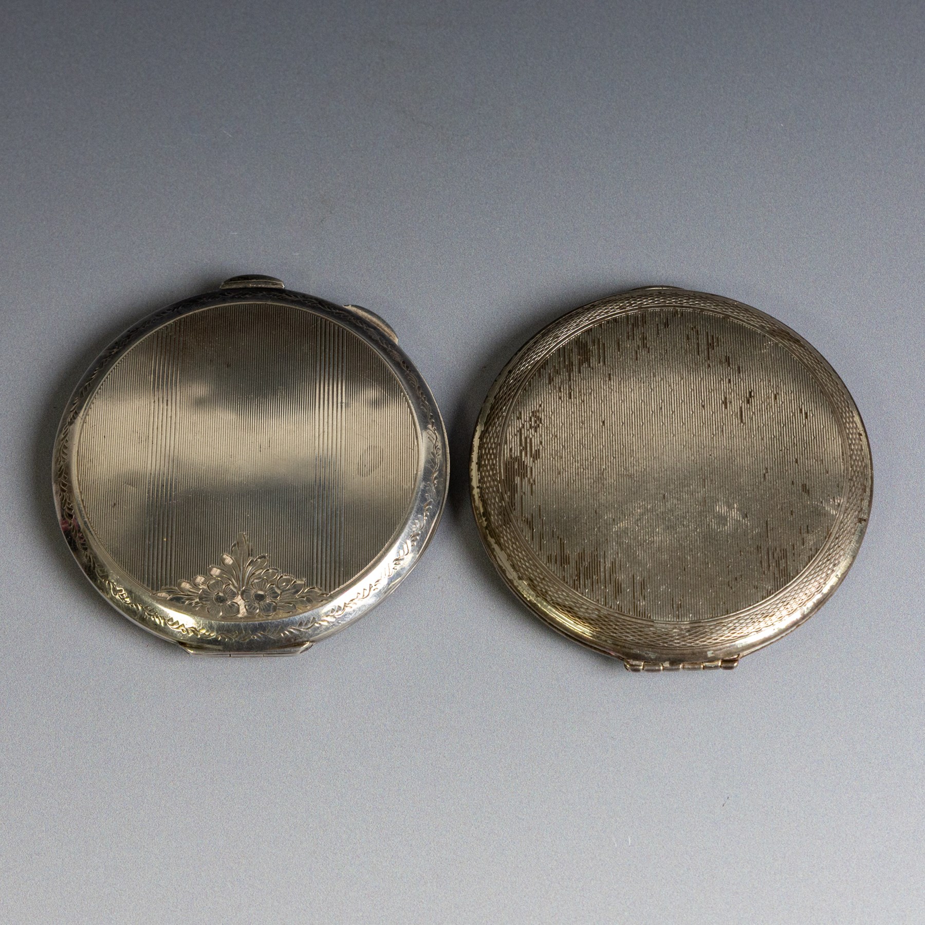 Two silver compact mirrors, comprising a Kigu powder compact with engine turned decoration and a compact mirror with floral decoration, both hallmarked