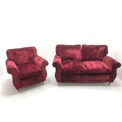 Two seat sofa (W166cm) and matching armchair (W92cm) upholstered in red velvet cover, turned supports, brass casters 