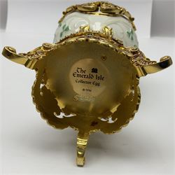 Franklin Mint The Emerald Isle Collector Egg, the egg decorated with embossed shamrocks upon a cream ground, with a gilded shamrock finial, accents and openwork door, opening to reveal a miniature landscape scene, upon three gilded feet set with green paste stones, with certificate of authenticity H23cm, 