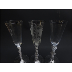  Three ale glasses comprising: round funnel bowl engraved with hops and barley above opaque air-twist stem on folded foot, H19.5cm, round funnel bowl on double knopped air twist stem and conical foot, H20cm, another with opaque twist stem (3)  