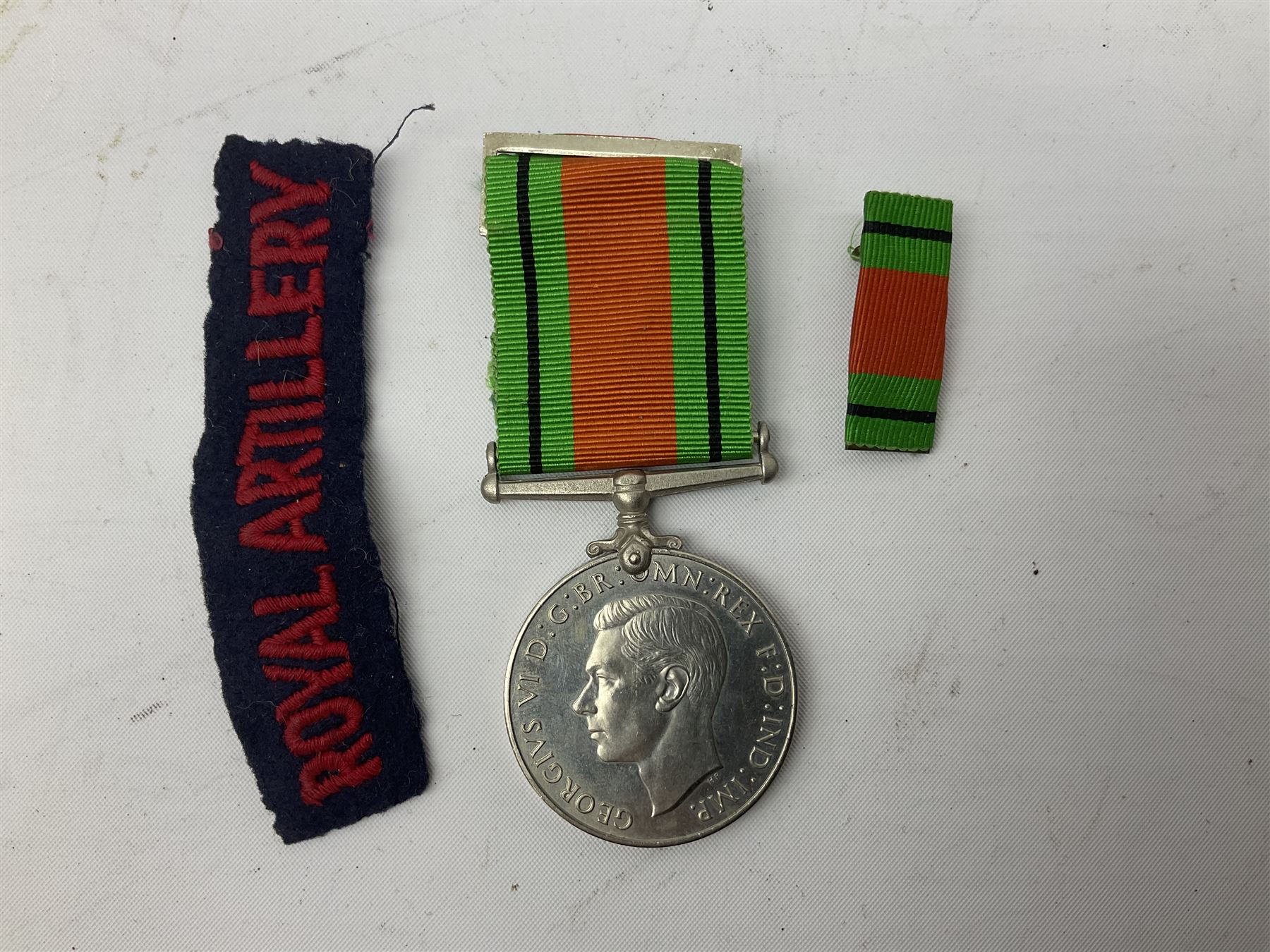 Royal Artillery 9ct gold and enamel sweetheart brooch in original box; together with Royal Artillery shoulder title, brass badges and buttons; and WW2 Defence Medal in issue box to 232775 addressed to Mrs. J.M. Morgan