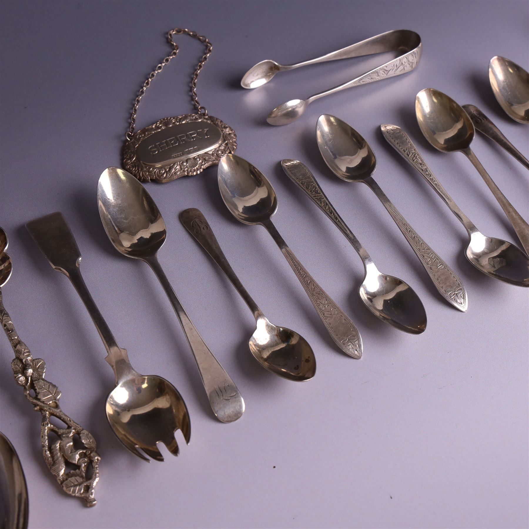 Collection of silver flatware, including pair of George III Fiddle patter table spoons and set of six Edwardian teaspoons with ivy decoration and matching sugar tongs, together with a silver 'Sherry' decanter label