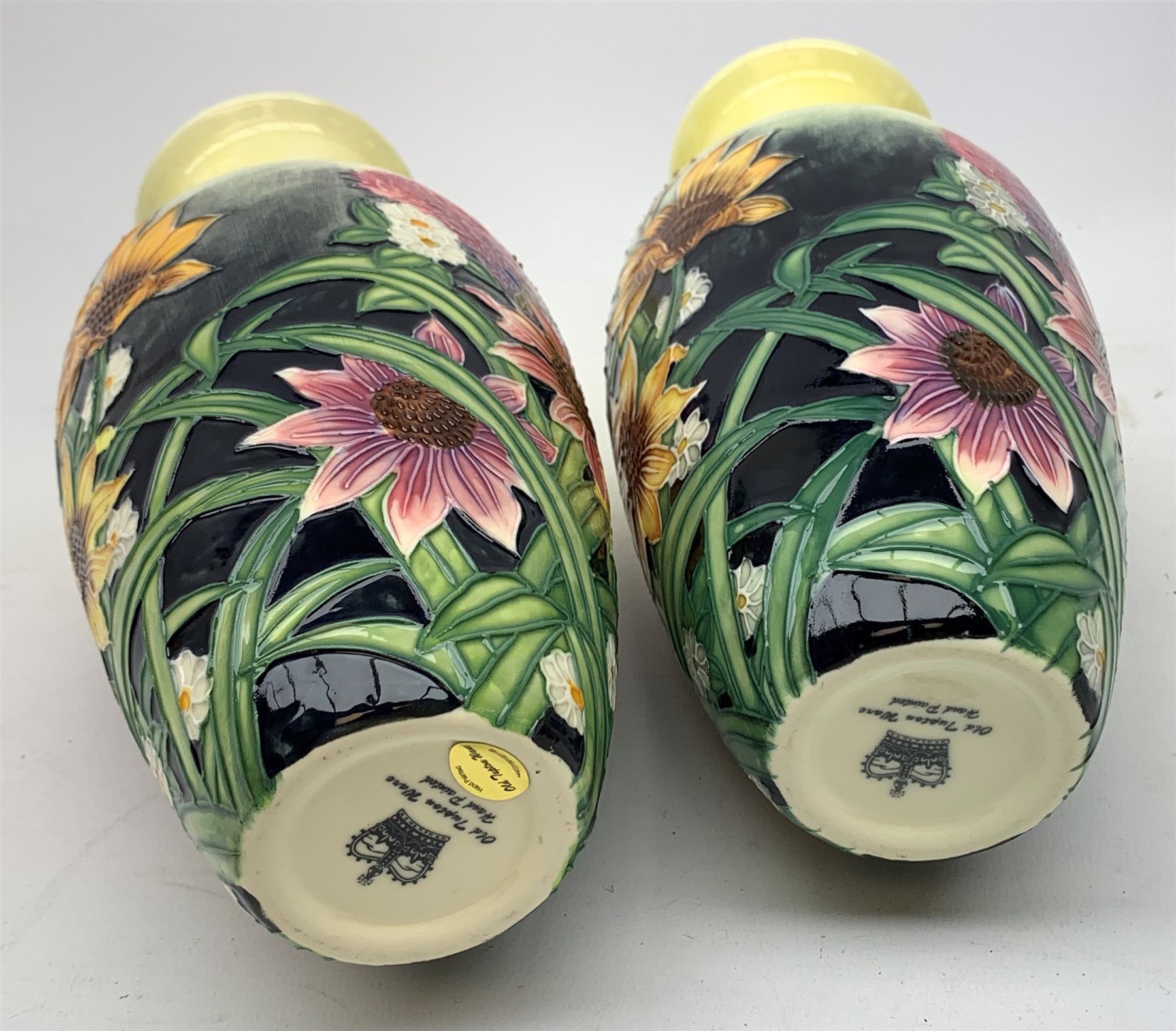 An Old Tupton Ware honey pot, of oval form with tube lined tendril decoration, the domed cover surmounted by a honey bee, with accompanying spoon, together with a pair of Old Tupton Ware vases, with tube lined sunflower decoration, H22cm, each with printed mark to base.