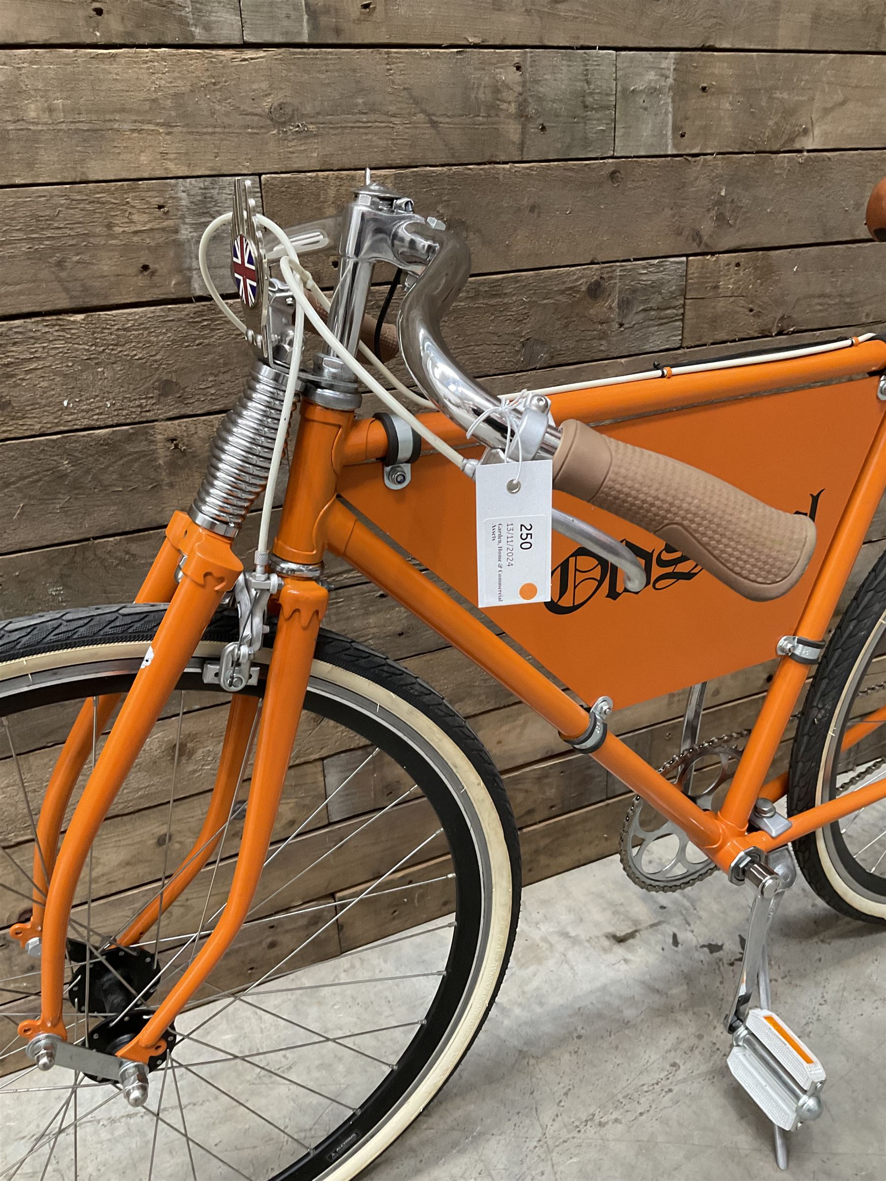 Fully restored vintage advertising bicycle with 2 stroke petrol engine, orange frame, tan leather seat