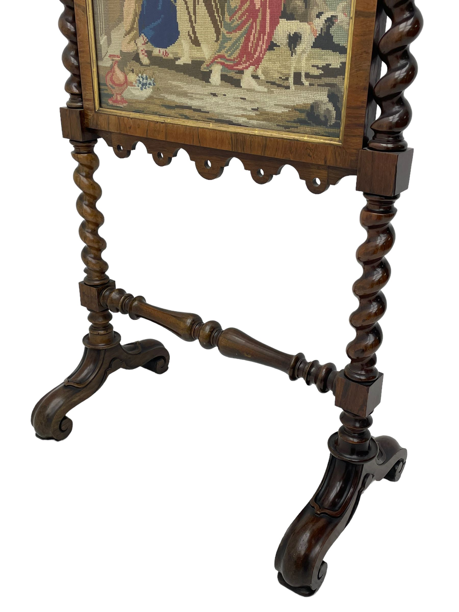 Victorian rosewood fire screen, scrolled foliage carved pediment, rectangular frame with moulded gilt slip enclosing figural needlework tapestry panel, on spiral turned supports with finials united by turned lower stretcher, on out-splayed feet with scroll carved terminals 