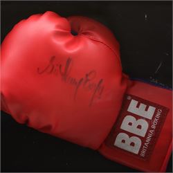 Framed display contained a single BBE Britannia boxing glove, signed by Sir Henry Cooper, displayed with a black and white print of Cooper with Ali on the ropes, with certificate of authenticity by Superstars For You, frame H59cm
