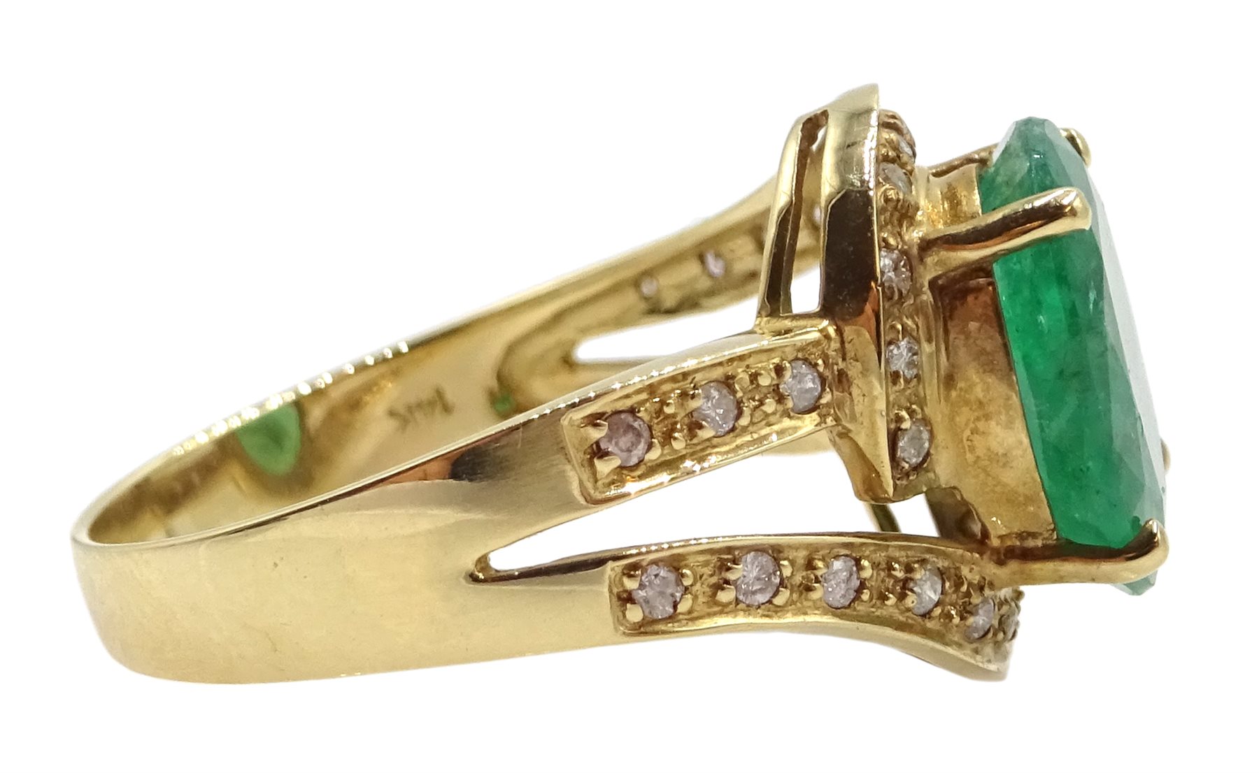 Gold oval emerald ring with diamond swirl surround and shank, stamped 14K