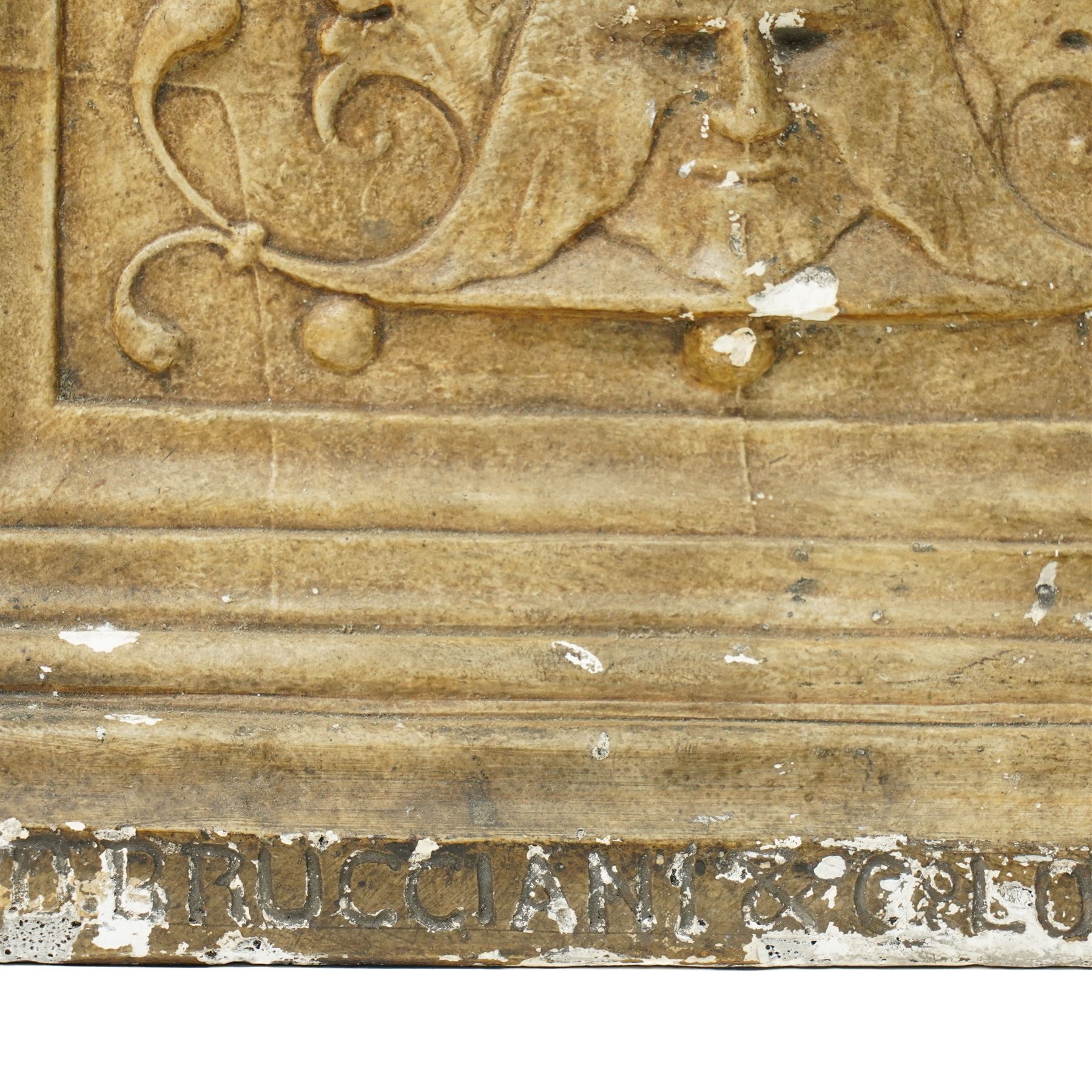 D Brucciani, London - After the antique -  A relief moulded plaster panel No2538 with stylised trailing leaves, flower heads and a mask 62cm x 22cm