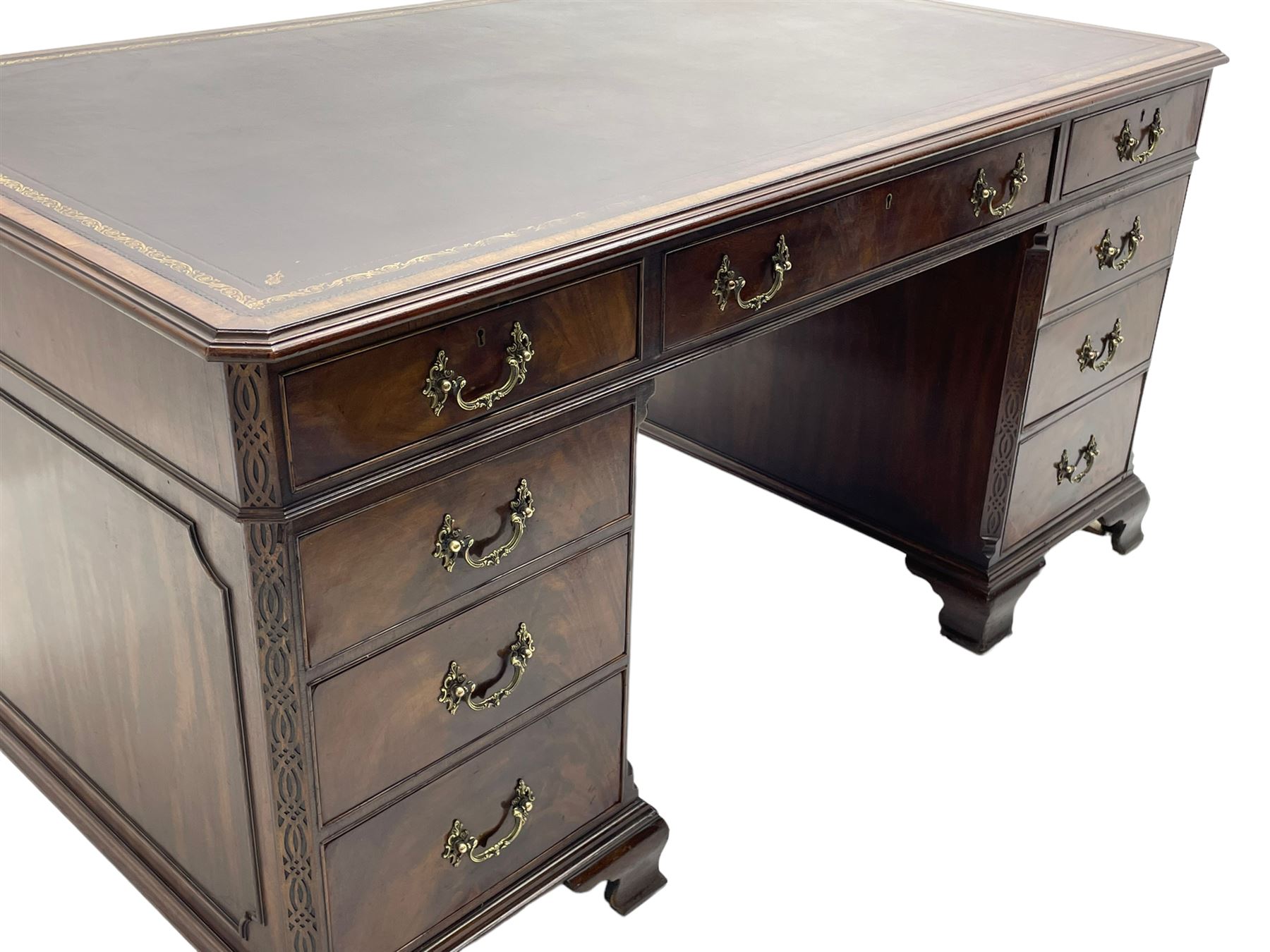Large Georgian design mahogany twin pedestal partner's desk, moulded rectangular top with canted corners and inset leather writing surface, fitted with nine drawers and two cupboards, the pedestals with canted uprights decorated with blind fretwork, on ogee bracket feet