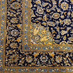 Central Persian Kashan hand-knotted rug, deep indigo field with central floral medallion surrounded by an all-over arrangement of palmettes, flowering vines, and tendrils with matching spandrels enclosed by a pale blue floral main border with multiple narrow guard stripes, with cotton fringe ends 